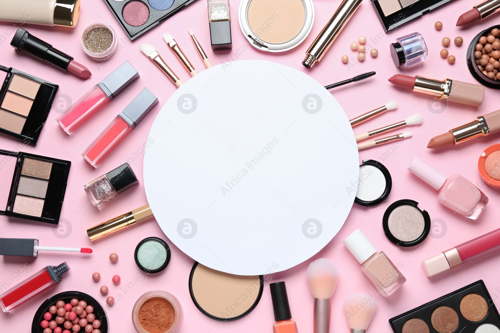 Photo of Flat lay composition with makeup products and blank round card on pink background, space for text