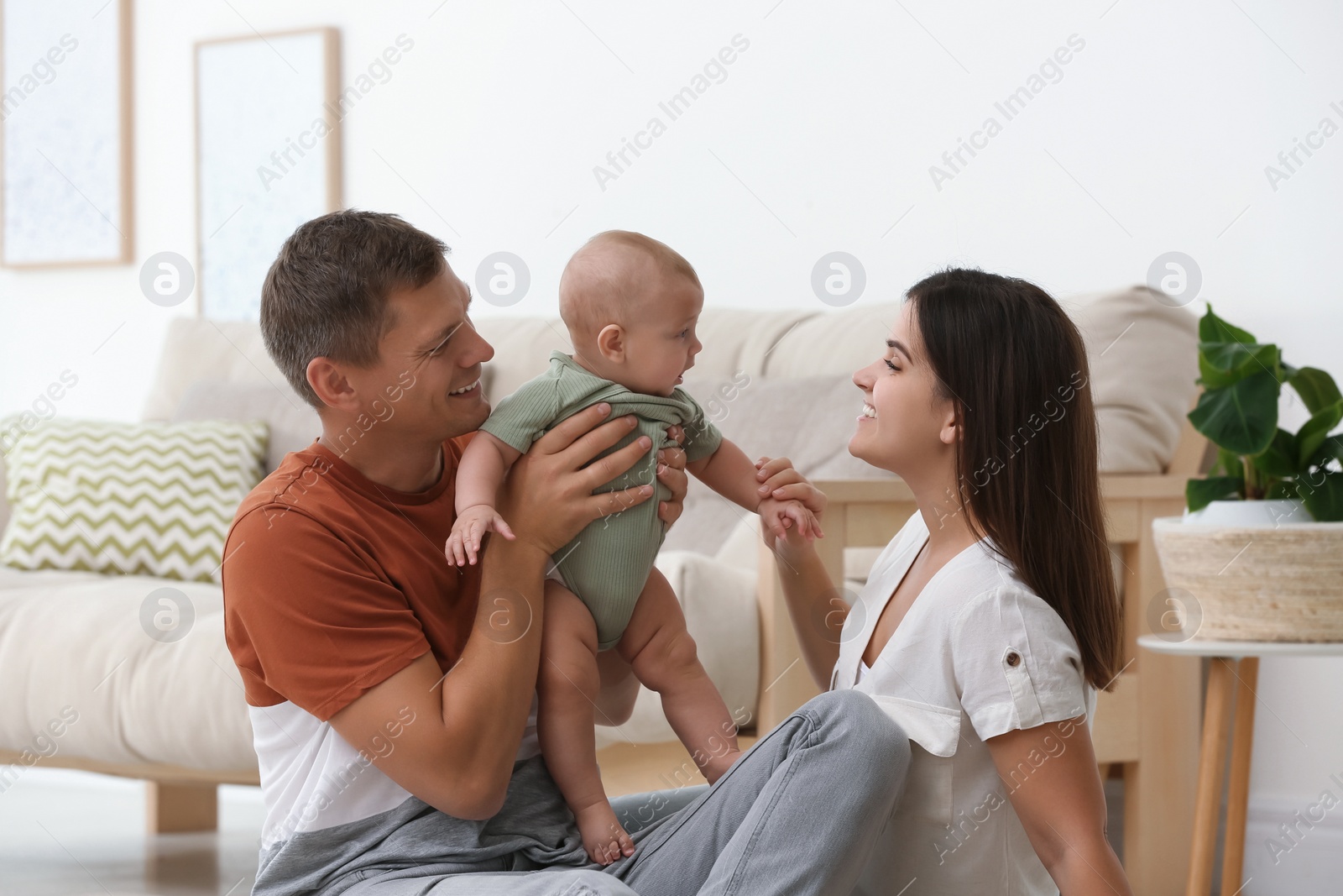 Photo of Portrait of happy family with their cute baby at home