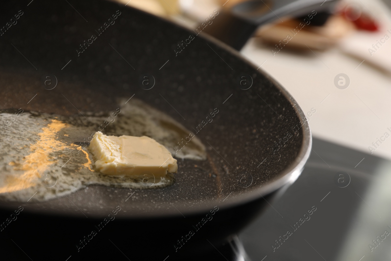 Photo of Frying pan with melted butter on stove, closeup