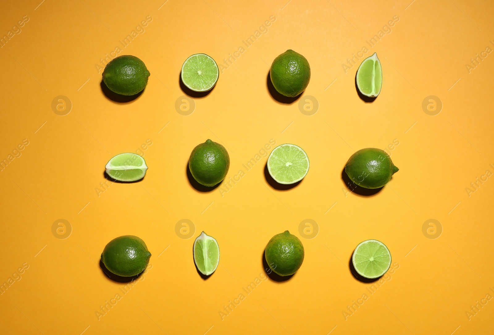 Photo of Flat lay composition with fresh juicy limes on yellow background