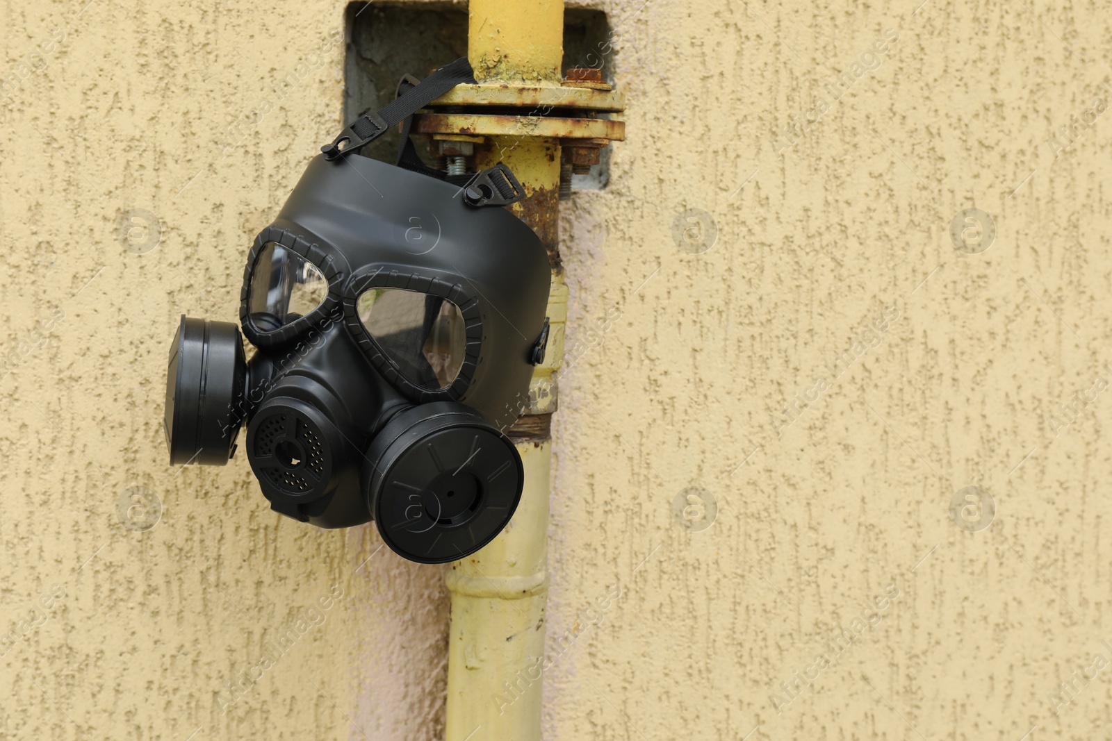 Photo of One gas mask hanging on building outdoors. Space for text