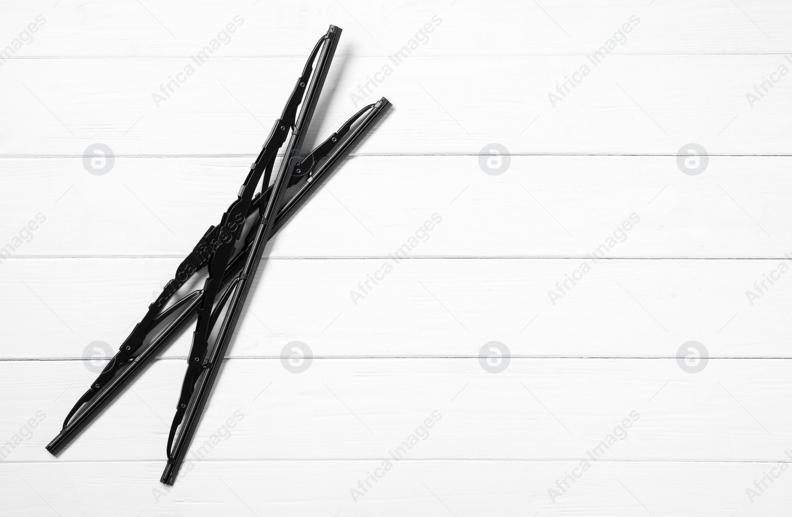 Photo of Car windshield wipers on white wooden background, flat lay. Space for text