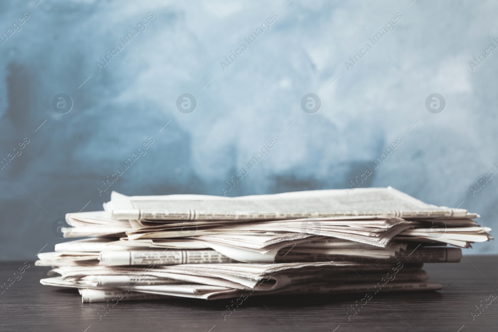 Image of Pile of newspapers on blue background, space for design. Journalist's work