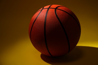 Photo of One new basketball ball on color background, closeup