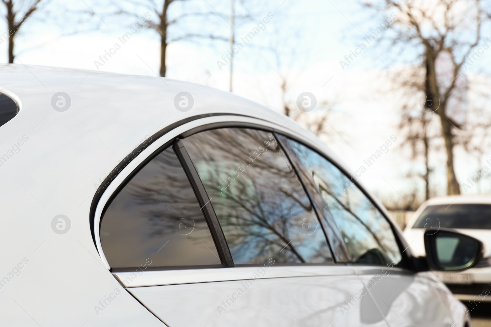 Photo of Modern car with tinting foil on window outdoors, closeup