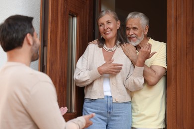 Photo of Friendly relationship with neighbours. Man visiting elderly couple