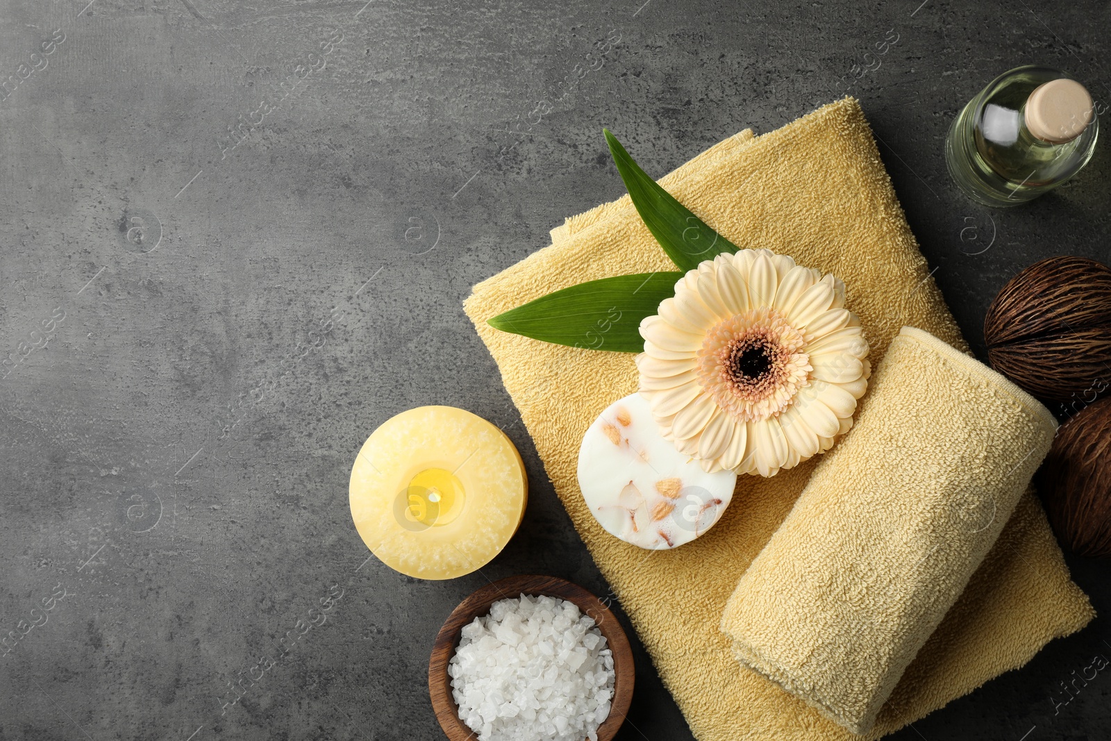 Photo of Flat lay composition with different spa products and candle on grey table. Space for text