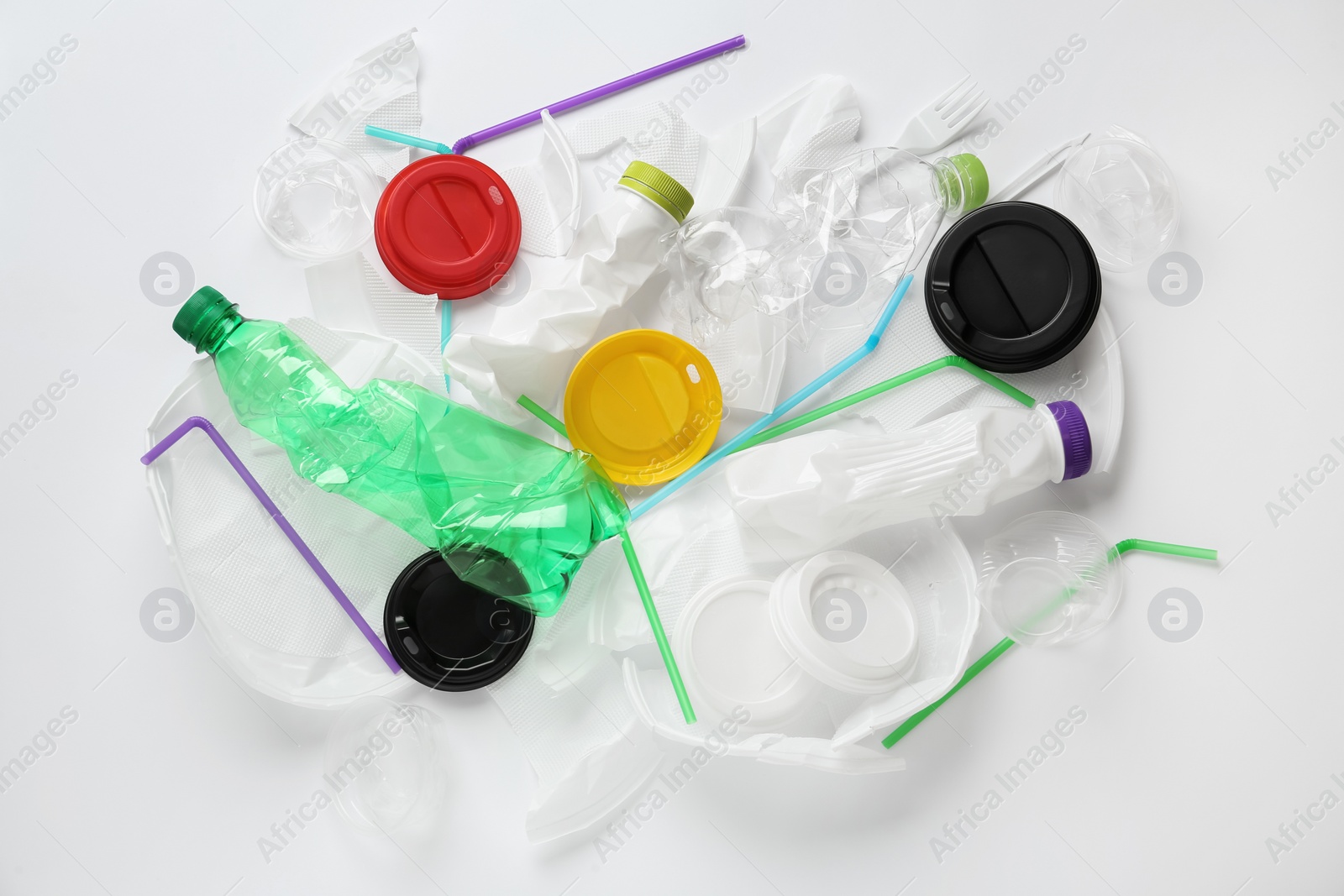 Photo of Pile of different plastic items on white background, flat lay