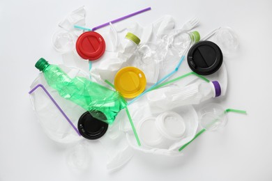 Pile of different plastic items on white background, flat lay