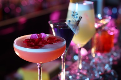 Photo of Different fresh alcoholic cocktails on blurred background, closeup
