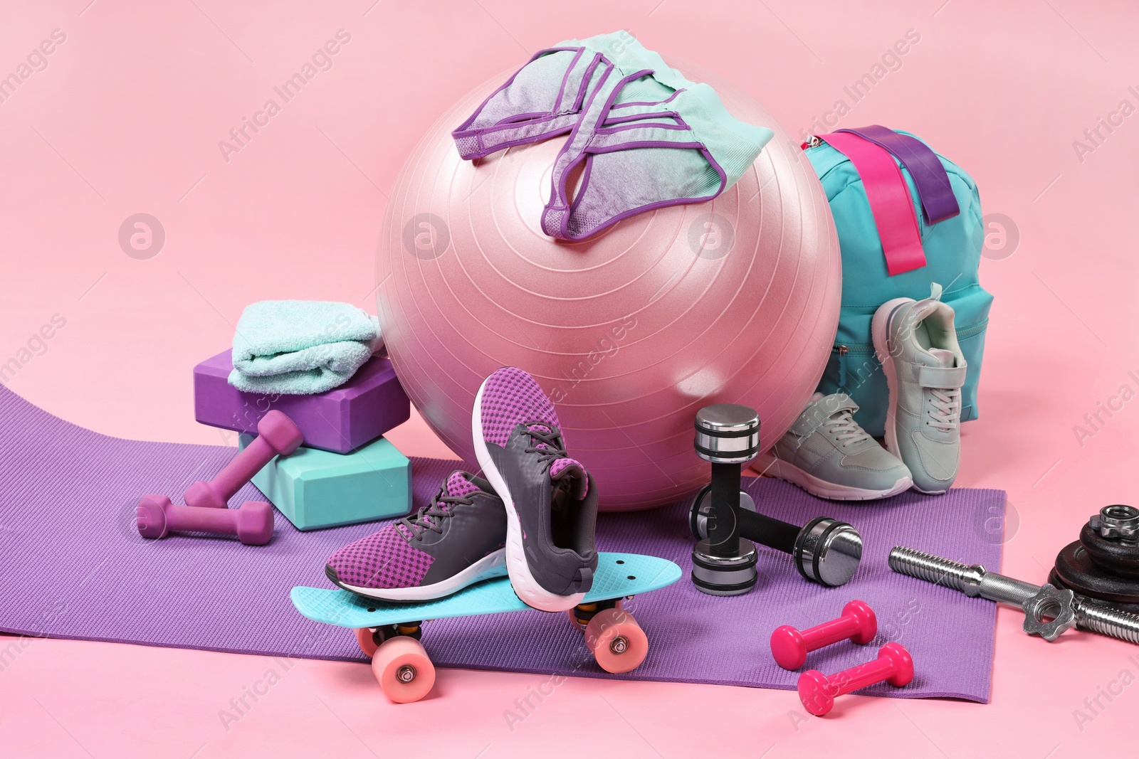 Photo of Many different sports equipment on pink background