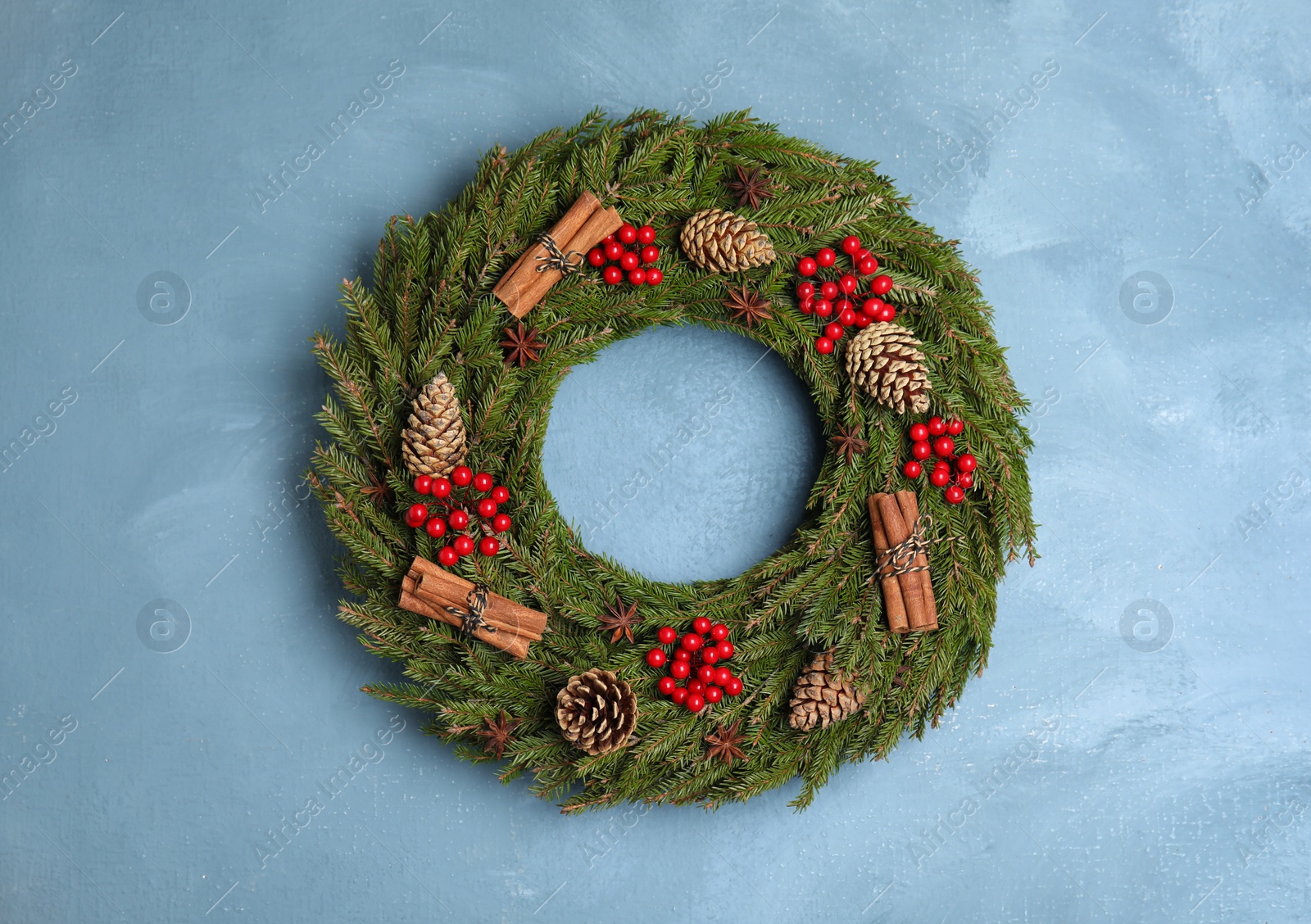 Photo of Beautiful Christmas wreath on light blue wall