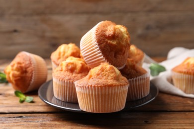 Photo of Delicious sweet muffins on wooden table, closeup