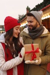 Photo of Lovely couple with Christmas present at winter fair