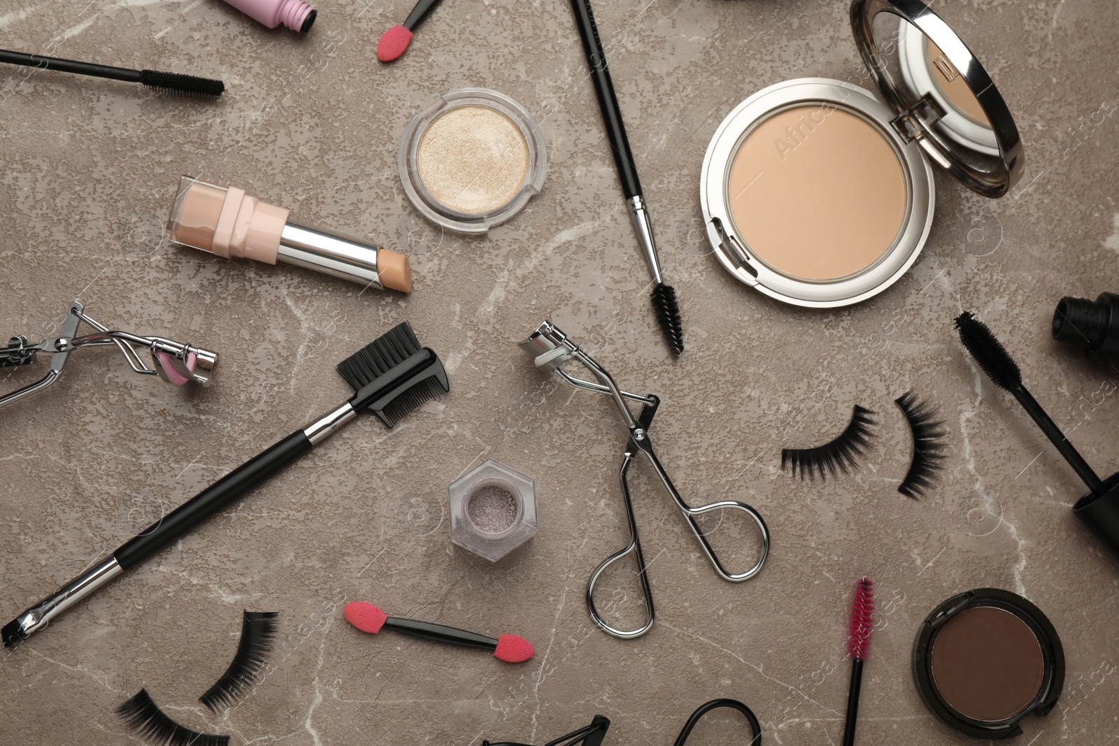 Photo of Flat lay composition with eyelash curler, makeup products and accessories on grey table