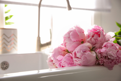 Photo of Bouquet of beautiful pink peonies in kitchen sink