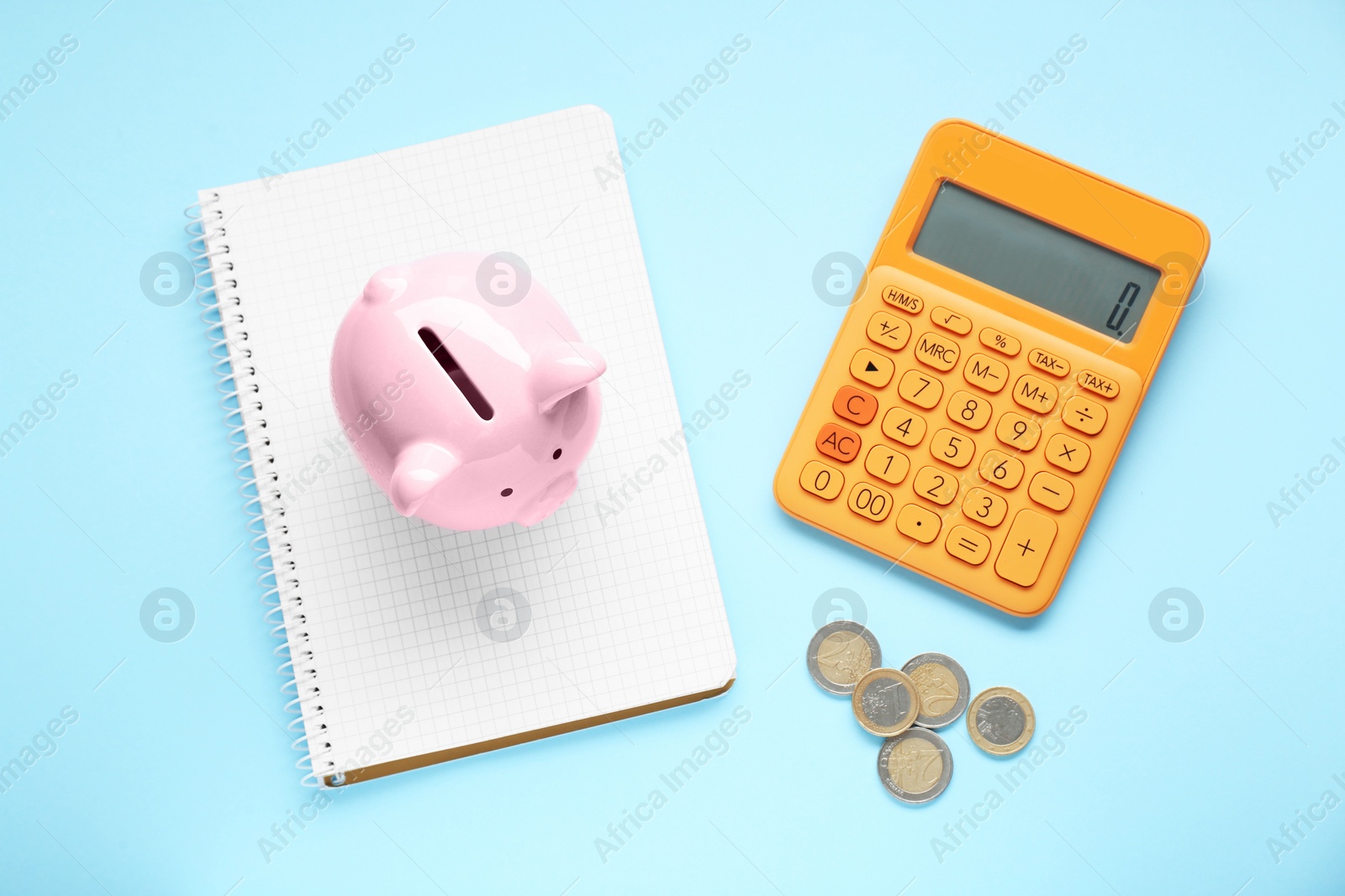 Photo of Piggy bank, coins, notebook and calculator on light blue background, flat lay