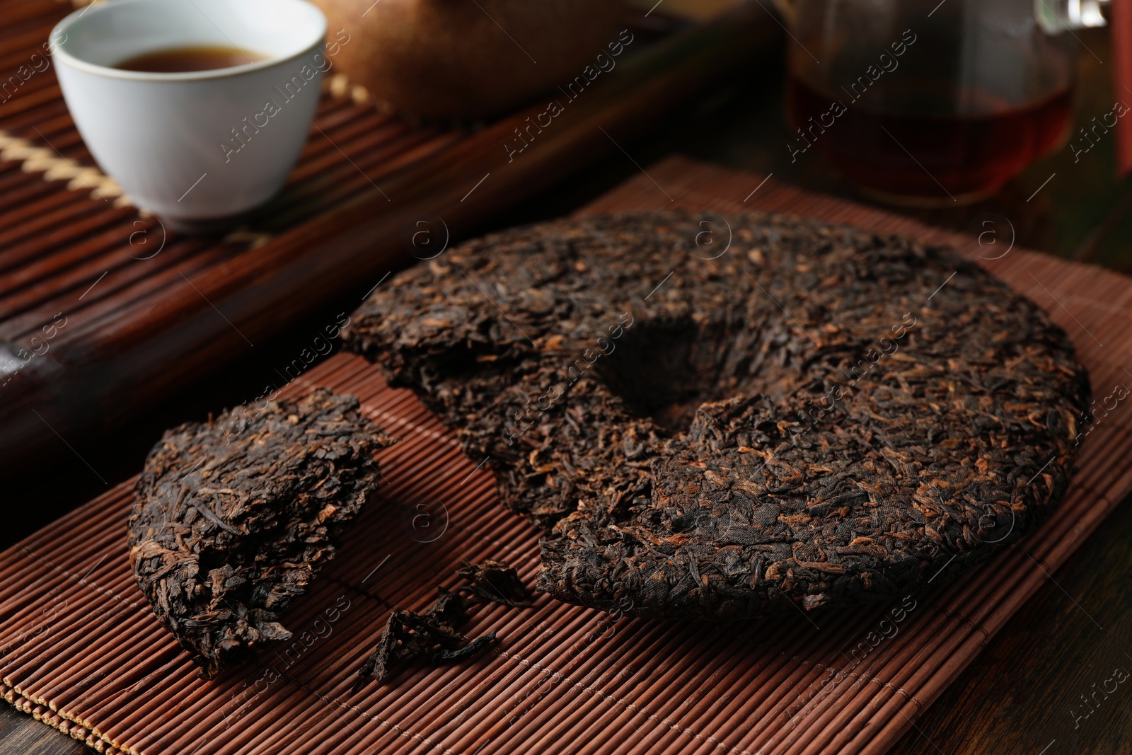 Photo of Broken disc shaped pu-erh tea on wooden table