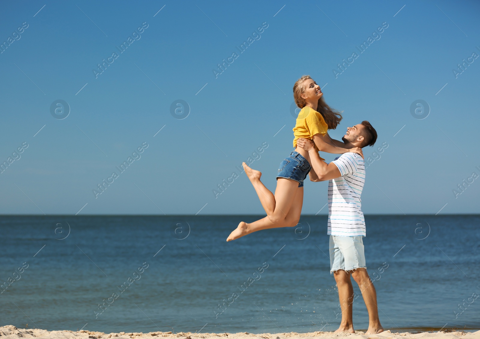 Photo of Happy young couple having fun at beach on sunny day