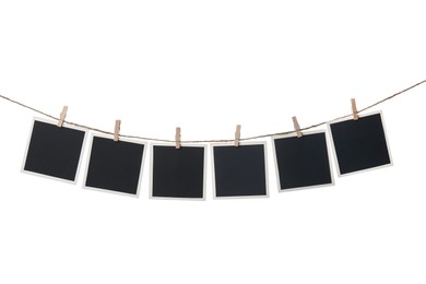 Photo of Clothespins with empty instant frames on string against white background. Space for text