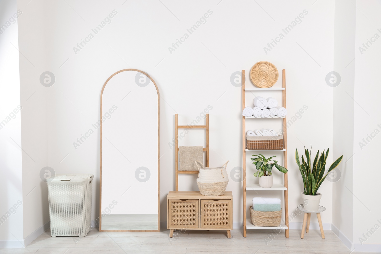 Photo of Stylish decorative ladders with clean towels and other furniture in room