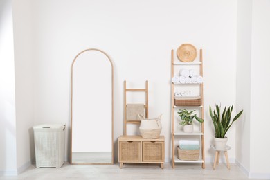 Stylish decorative ladders with clean towels and other furniture in room