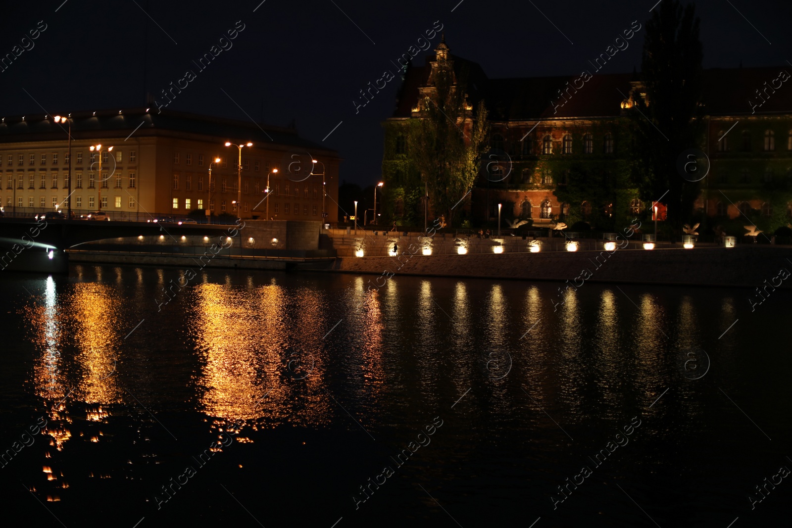 Photo of Beautiful view of illuminated city near river at night