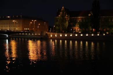 Photo of Beautiful view of illuminated city near river at night