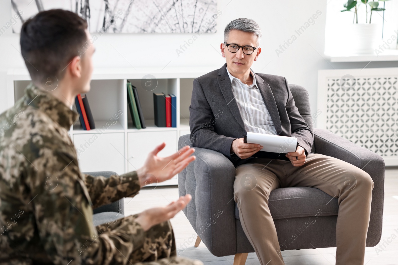 Photo of Professional psychotherapist working with military man in office