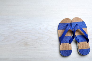 Stylish flip flops on white wooden background, flat lay. Space for text