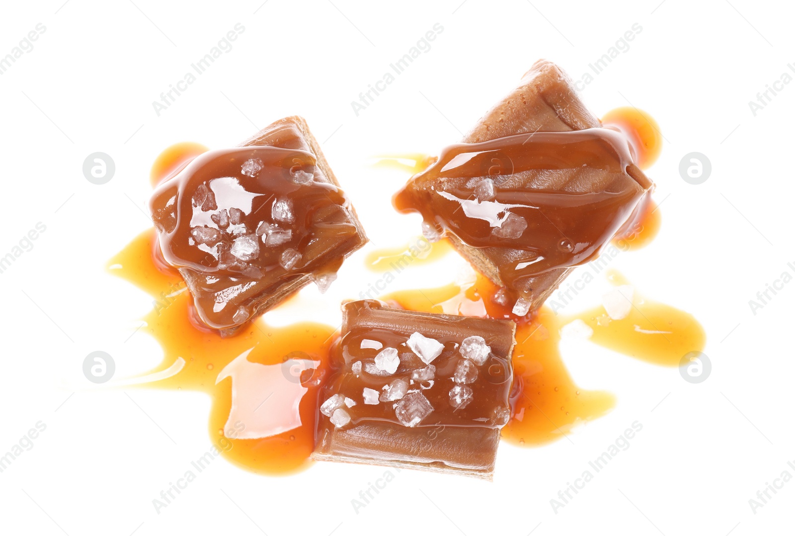 Photo of Delicious salted caramel with sauce on white background, top view