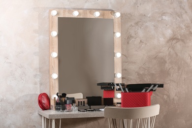 Photo of Dressing table with different makeup products and accessories in room interior