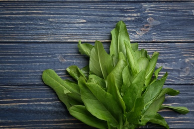 Fresh green sorrel leaves on blue wooden table, top view