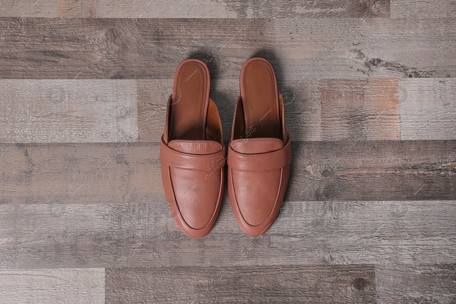 Photo of Pair of female shoes on wooden background, top view