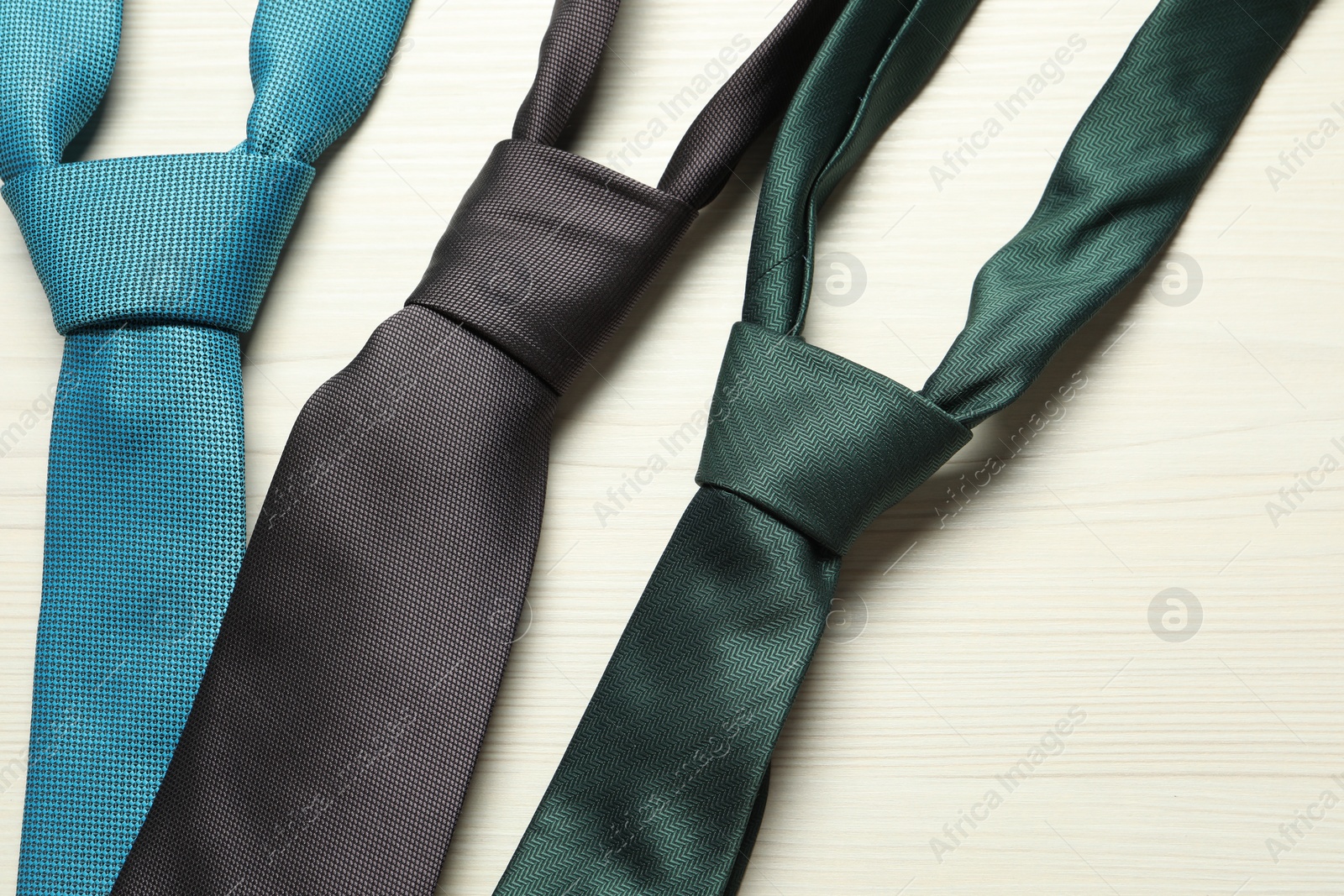 Photo of Different neckties on white wooden table, flat lay