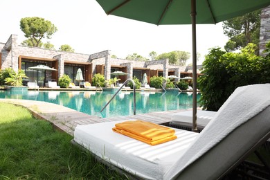 Sunbeds near outdoor swimming pool at luxury resort