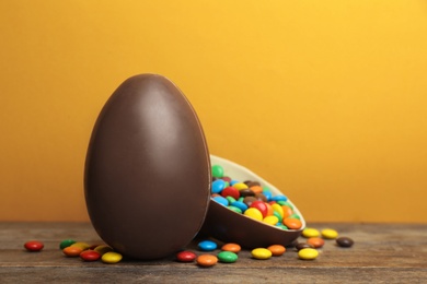 Photo of Composition with chocolate Easter eggs on table against color background. Space for text