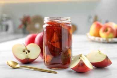 Photo of Delicious apple jam in jar and fresh fruits on white table