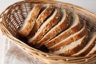 Photo of Slices of fresh homemade bread in wicker basket on table, closeup