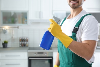 Photo of Janitor with sprayer in kitchen, closeup. Cleaning service
