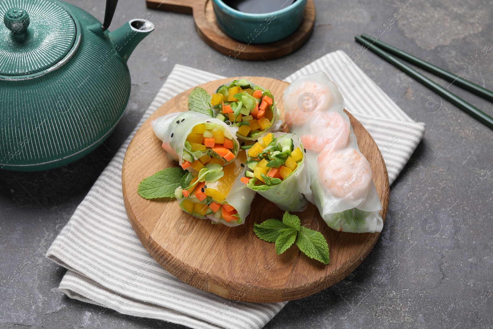 Photo of Tasty spring rolls on grey textured table, closeup