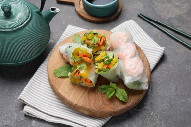 Photo of Tasty spring rolls on grey textured table, closeup