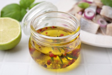 Tasty fish marinade in jar on light tiled table, closeup