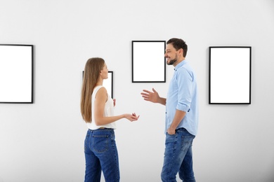 Photo of People viewing exposition in modern art gallery