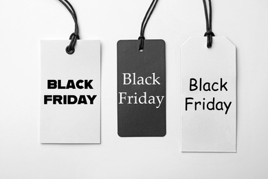 Different tags with text BLACK FRIDAY on white background, flat lay 