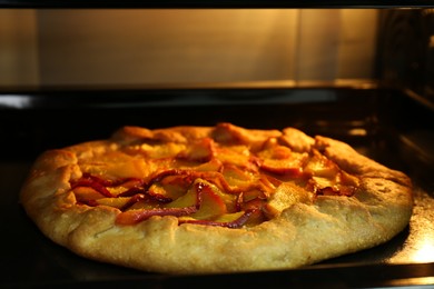 Photo of Baking delicious pie in electric oven, closeup