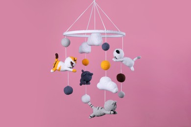Cute baby crib mobile on pink background