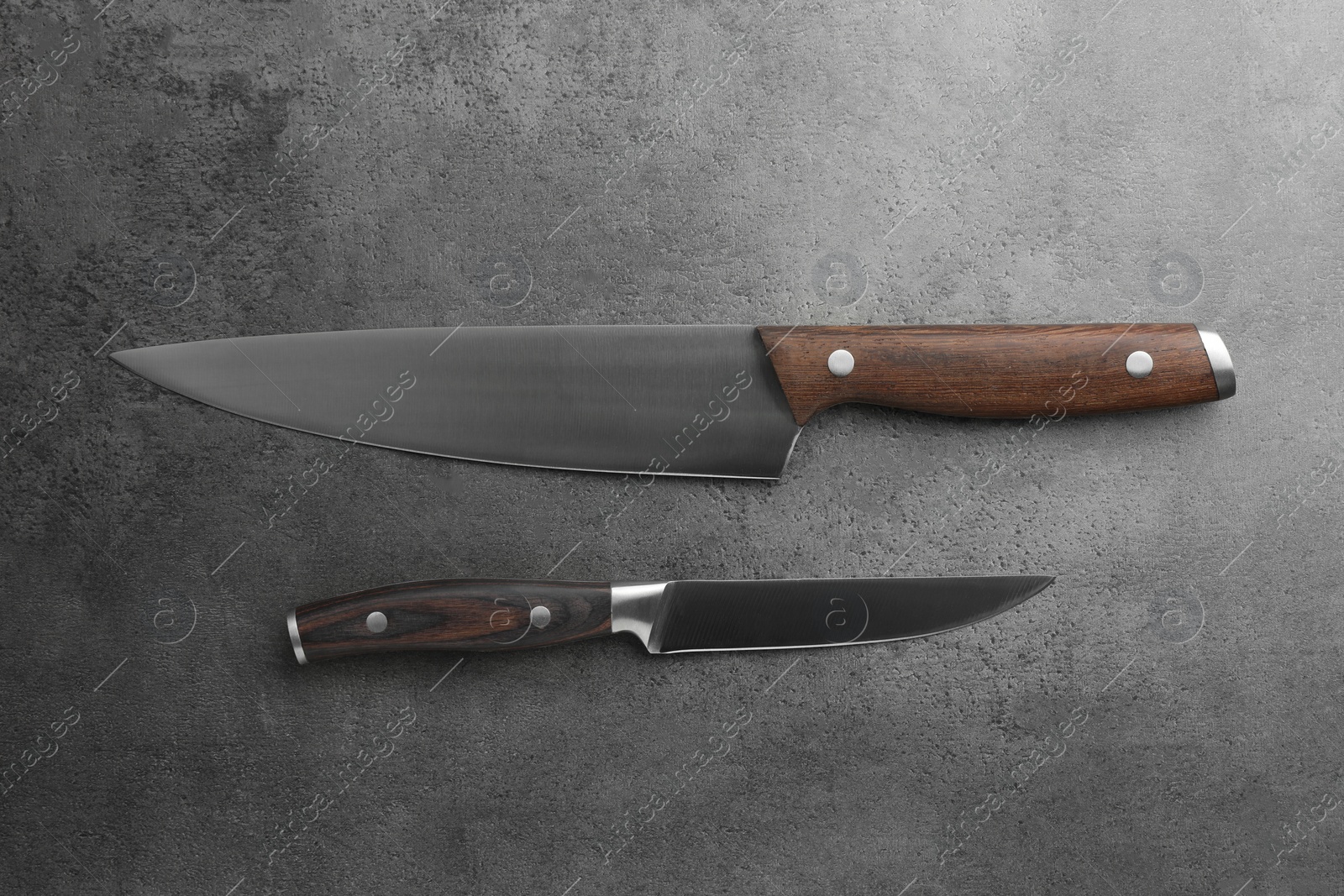 Photo of Knives on grey textured table, flat lay