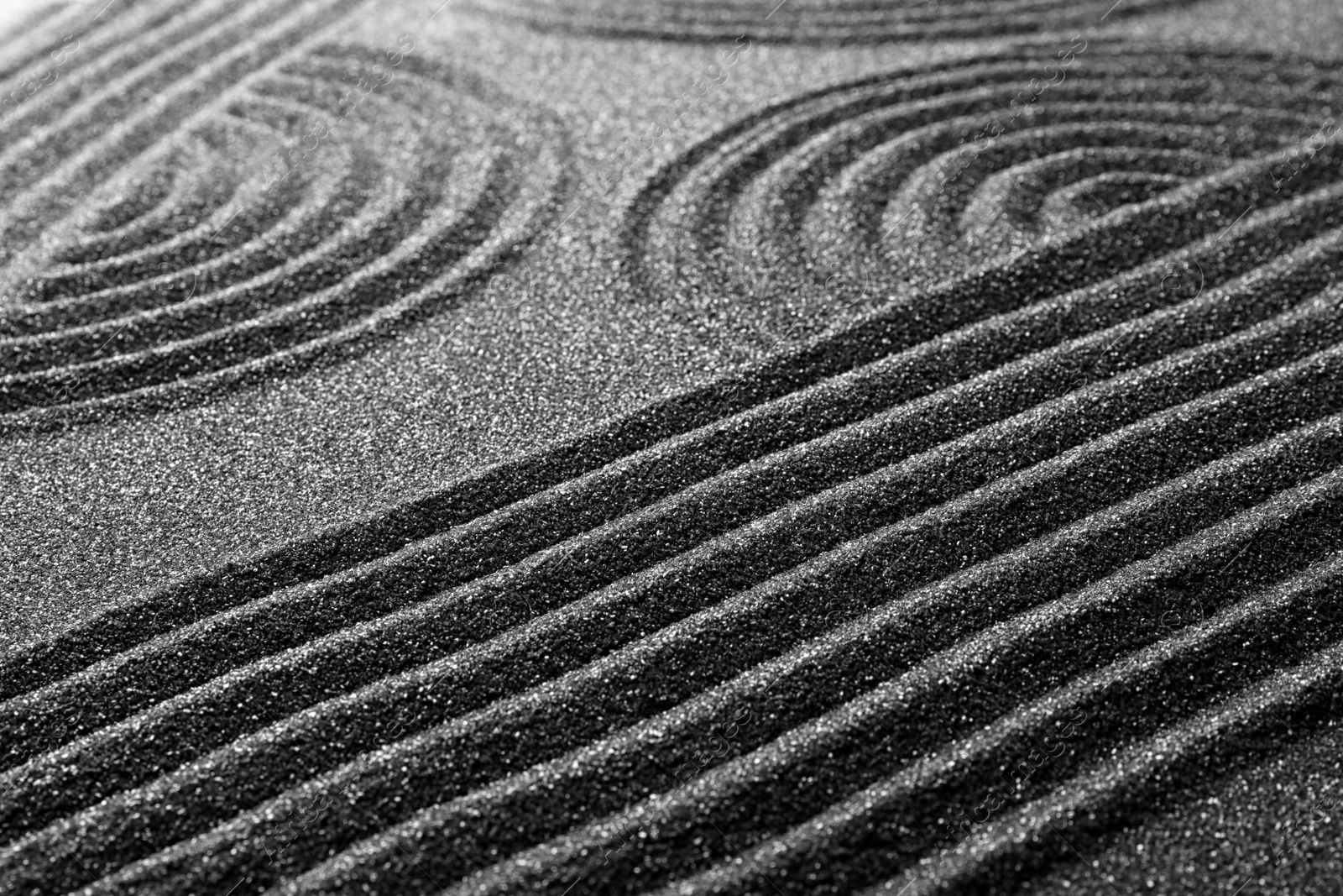Photo of Pattern on decorative black sand, closeup. Zen and harmony