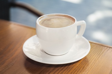 Photo of Aromatic coffee on wooden table outdoors, closeup